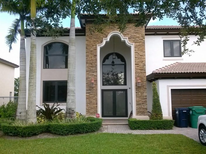 Custom home with hurricane impact arched entry door